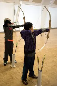 Kids with archery bows shooting a target