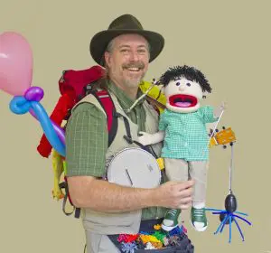 mr scott with hand puppet, backpack, banjo, balloons, and toys