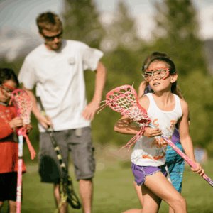 girl holding lacrosse stick on field