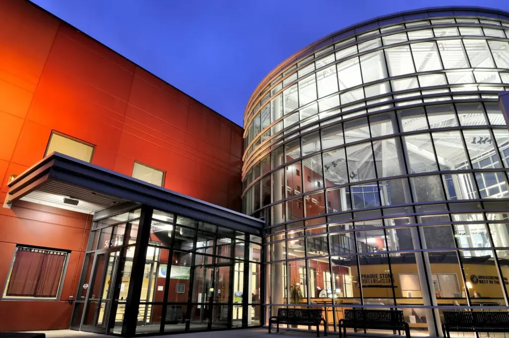 a building with glass walls and a red wall