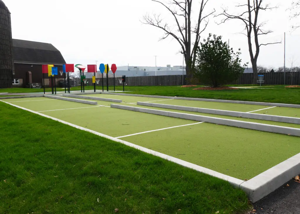 a green grass field with white lines and colorful signs