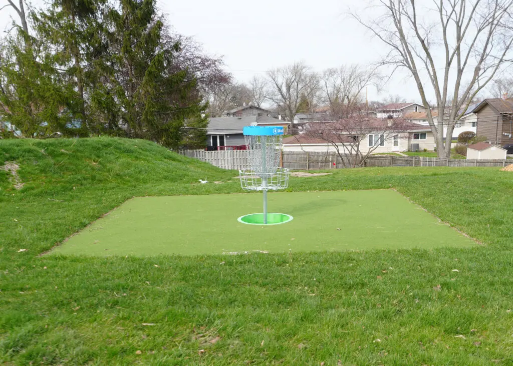 a golf course with a basket on the ground