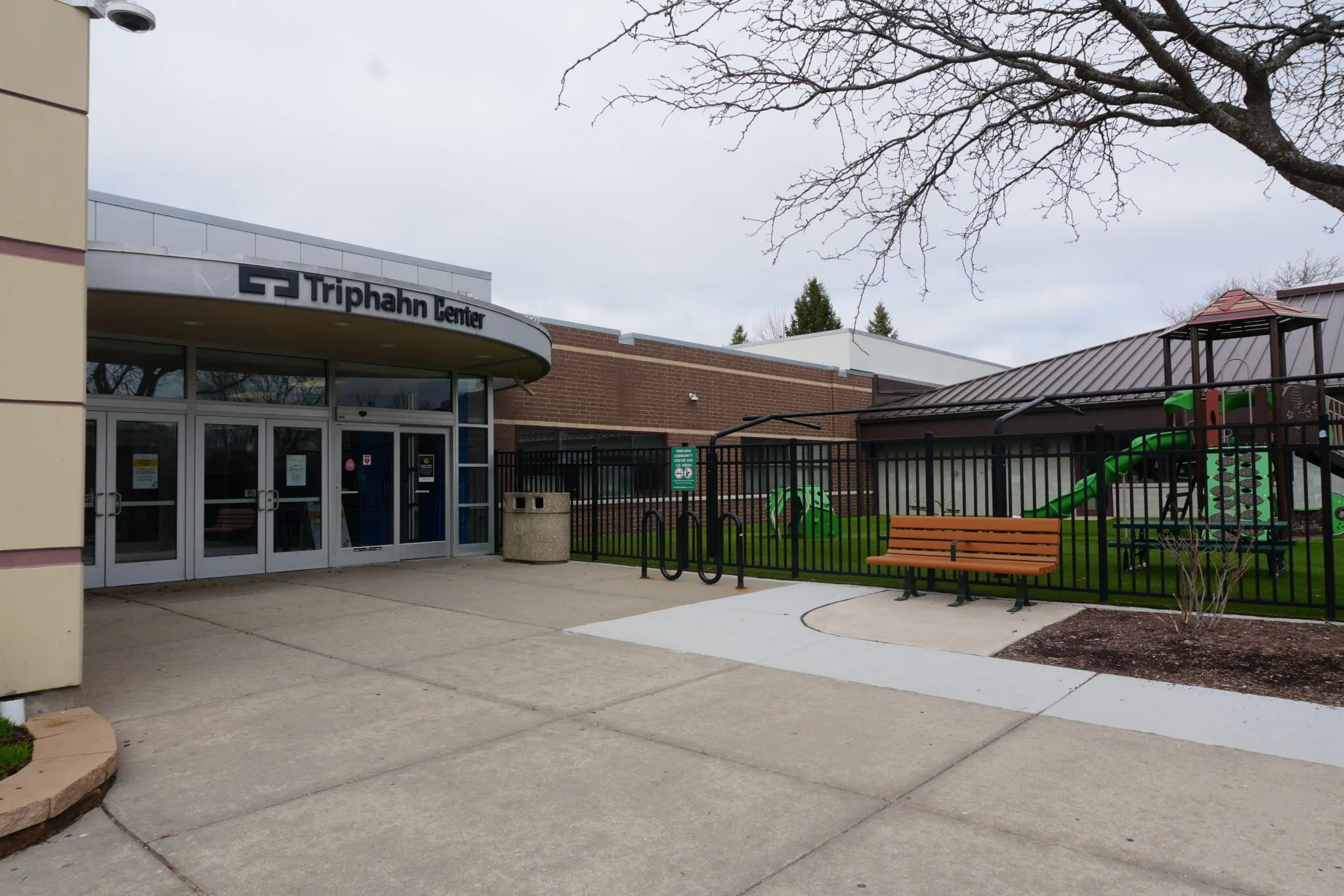 a building with a black fence and a bench