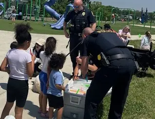 a police officer standing next to a group of kids