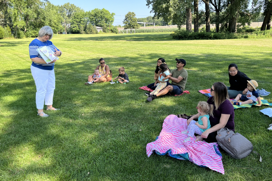 a group of people sitting on blankets in a park