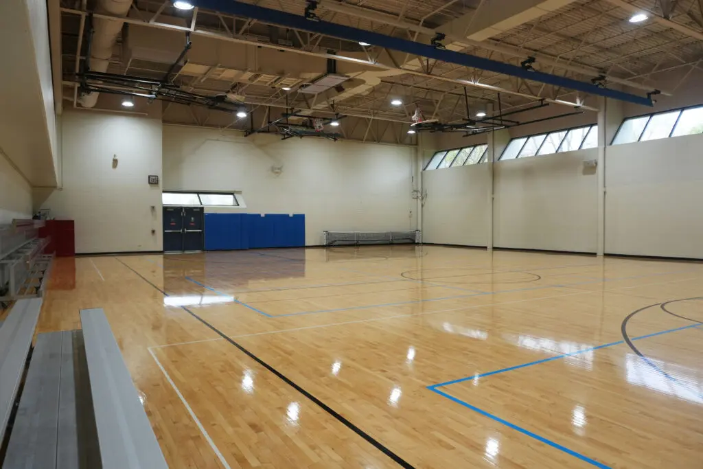 a gym with a wooden floor and blue walls