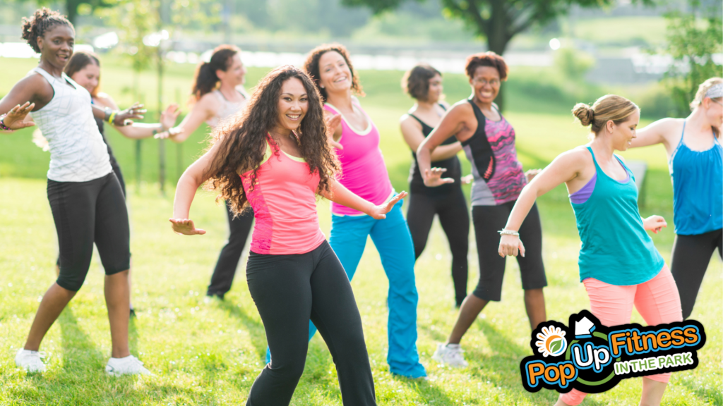 A group of people taking a Zumba class in the park