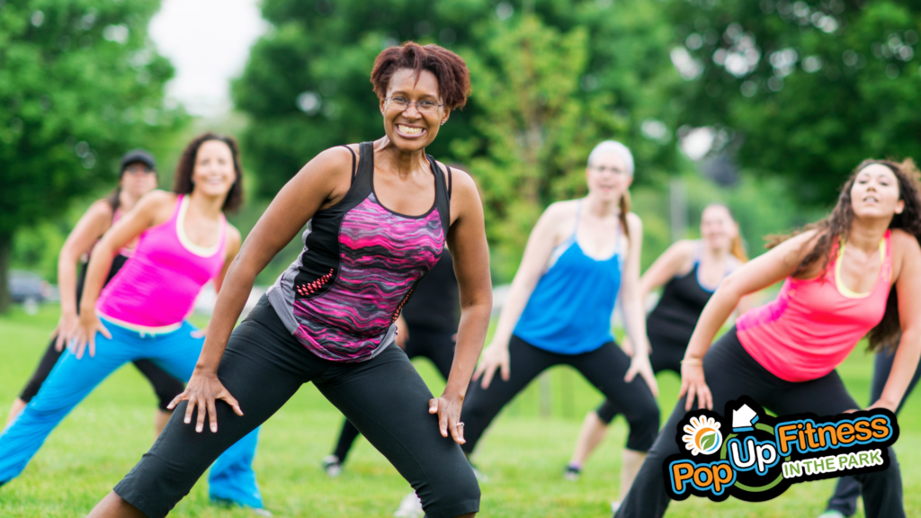 A group of people taking a Zumba class in the park