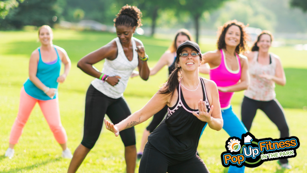 A group of people taking a Zumba class in the park