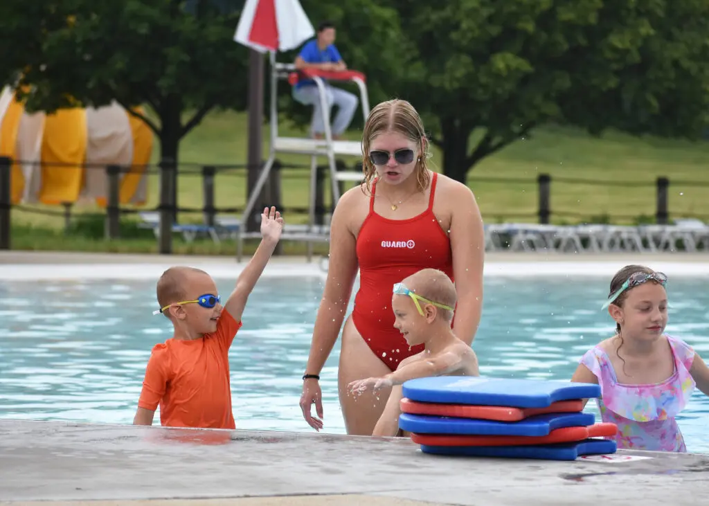 a person and kids in a pool