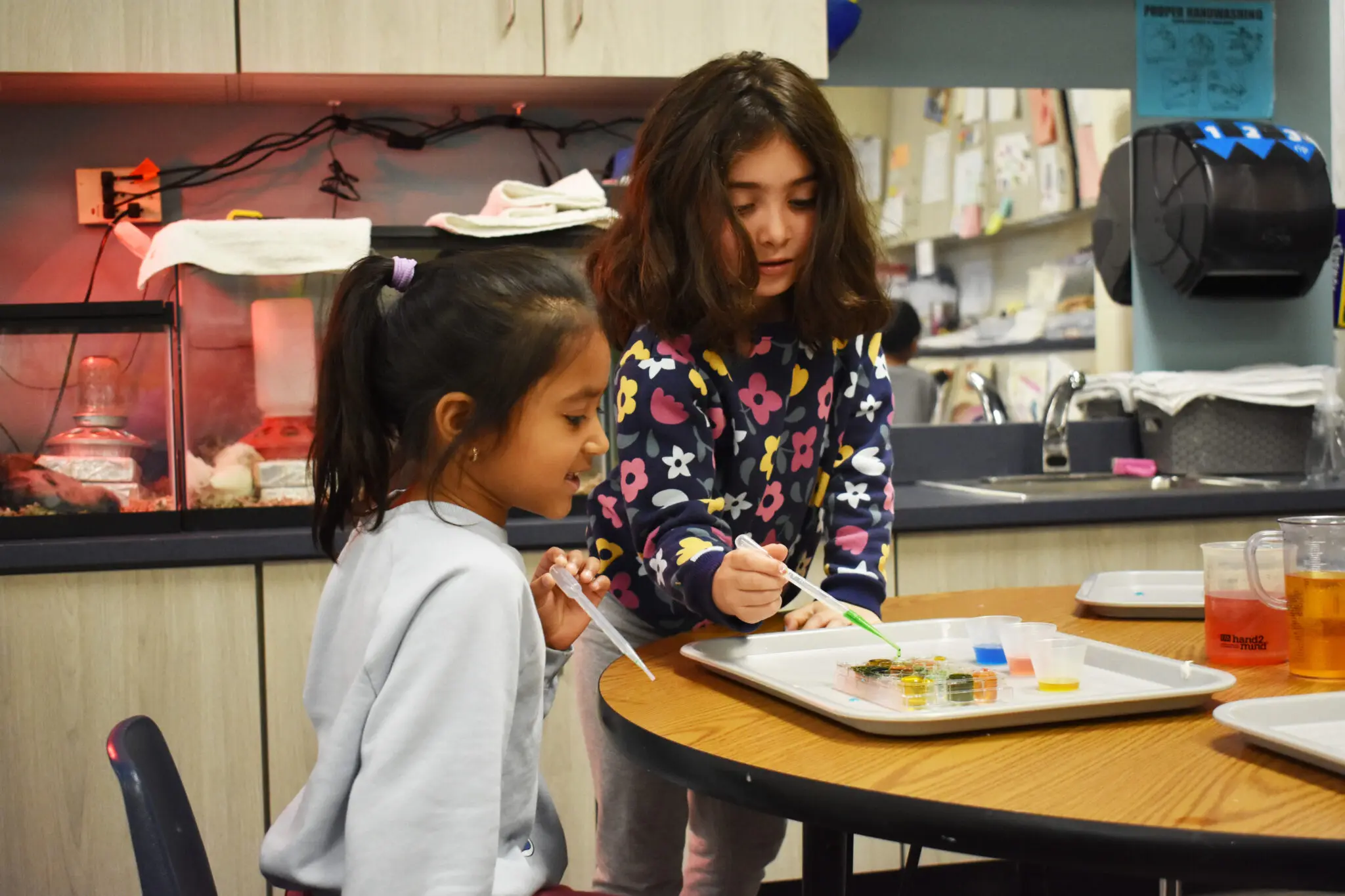 Two kids doing an experiment at the table