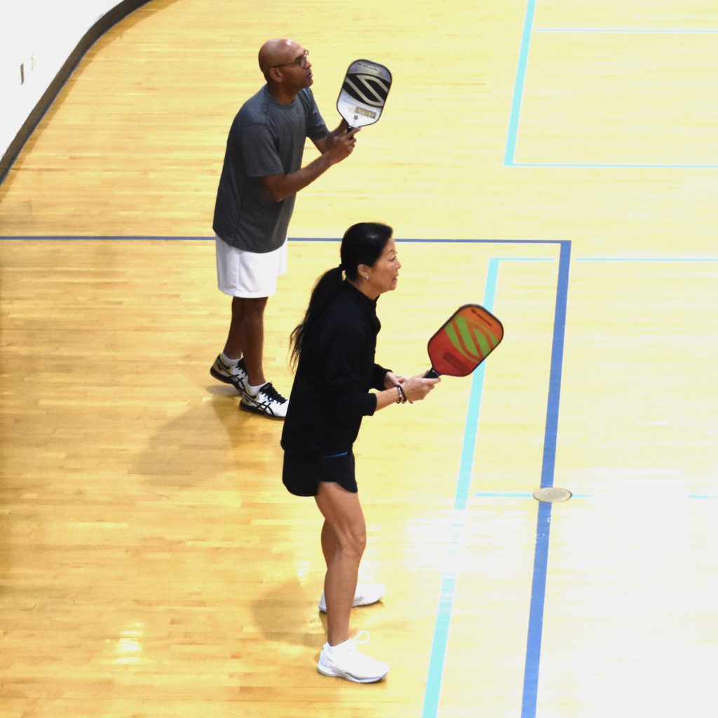 adults play pickleball